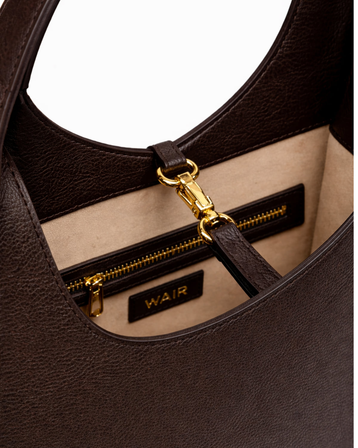 Interior of The Vessel in umber leather — leather-lined pockets, hardware, and stitching.